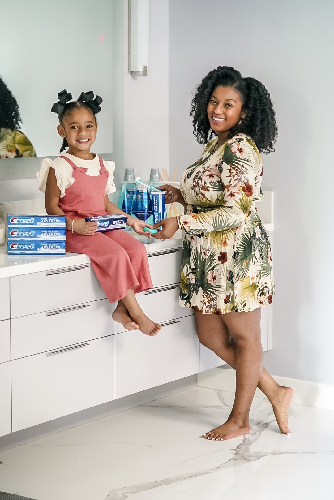 mother and daughter discussing whether you should brush or floss first using Crest products.